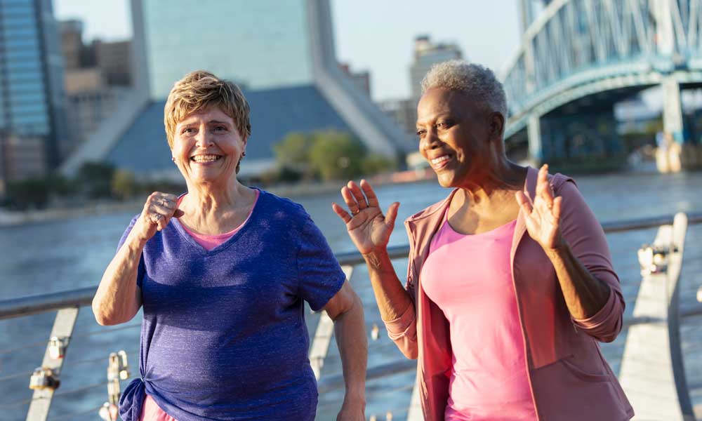 senior women having fun together on a city waterfront